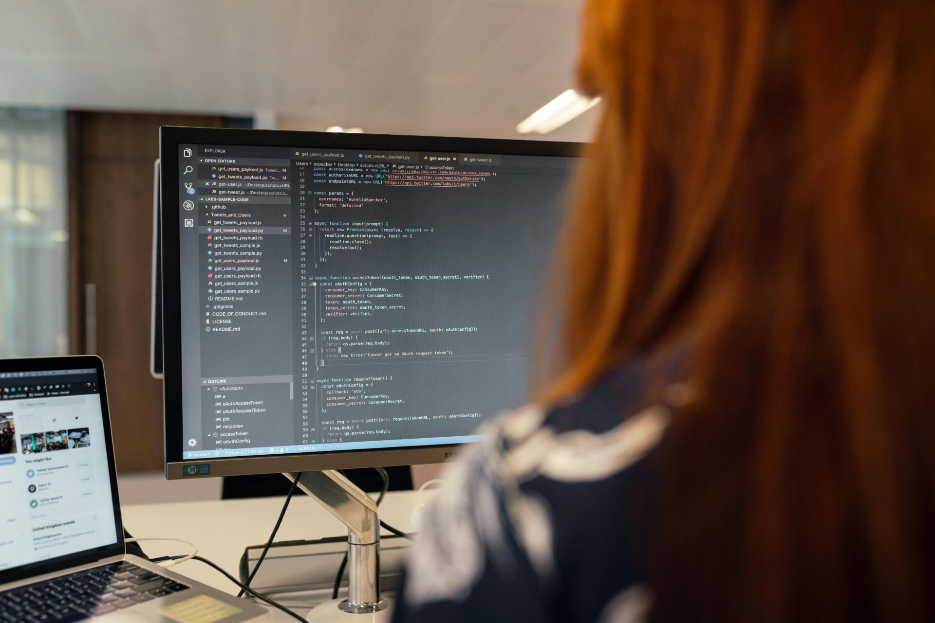 Woman coding on a desktop computer in a modern office, representing a skilled web developer and illustrating the question how much does a website cost through active software development work.