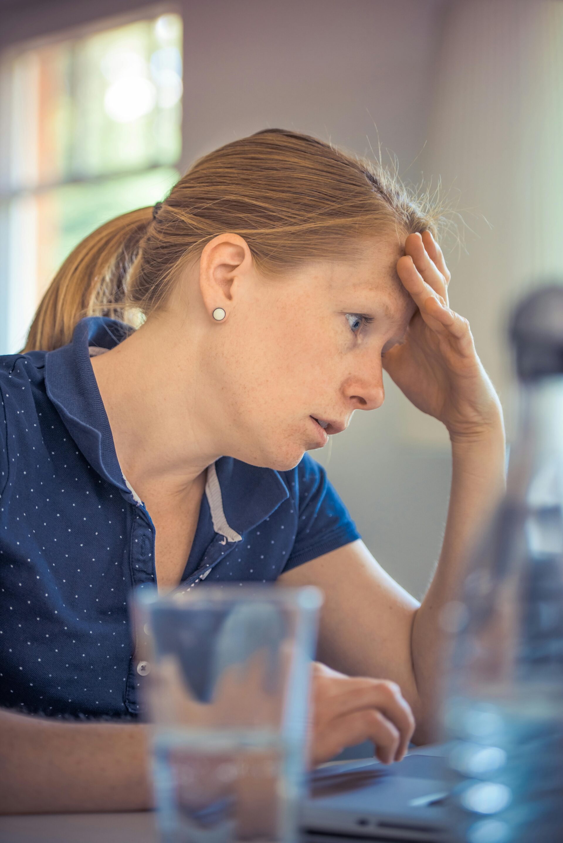 Stressed woman looking at laptop, wondering why her website is not getting